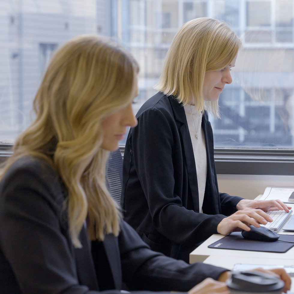 Two employees trying to reconcile employee credit card expenses manually instead of using a corporate expense management solution. 